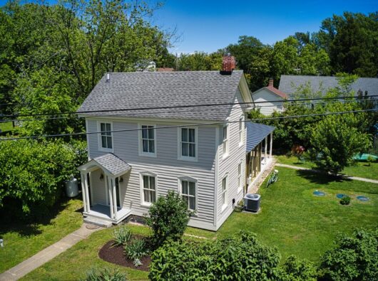 Privacy is achieved through dense landscaping while original wood siding restoration highlights period authenticity.