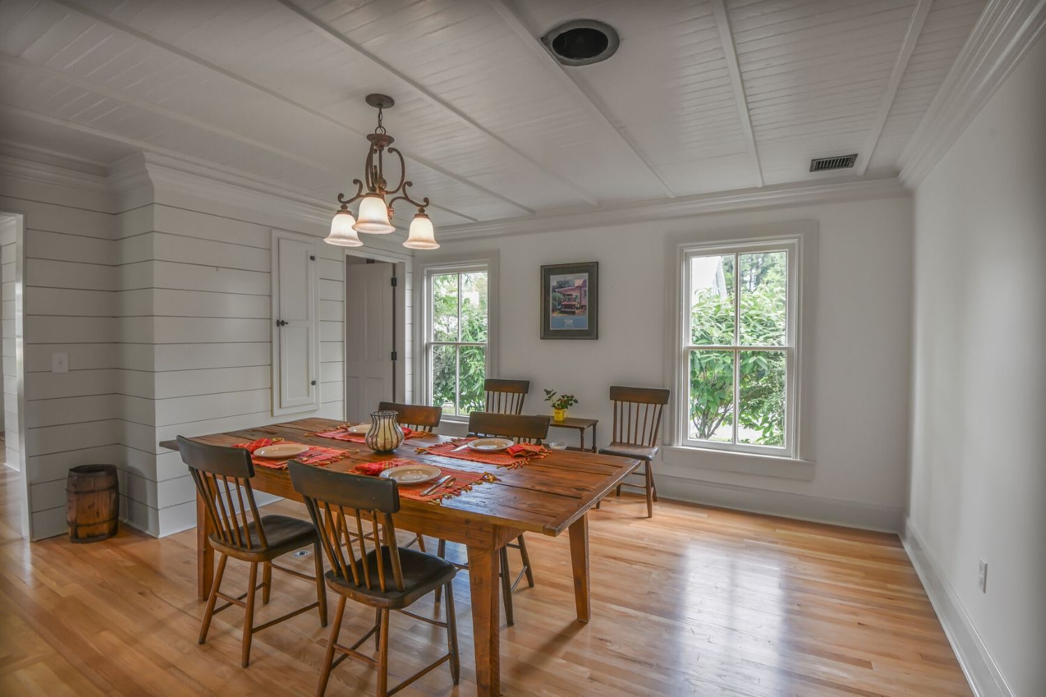 Wide openings connect spaces, while long windows enhance the dining room’s serene views of private greenery.